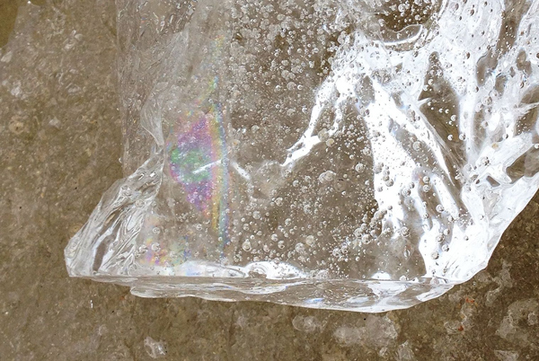 Eisvogelname, in diesem Eisstück, spiegel sich die Farben der Eisvogelfedern wieder.